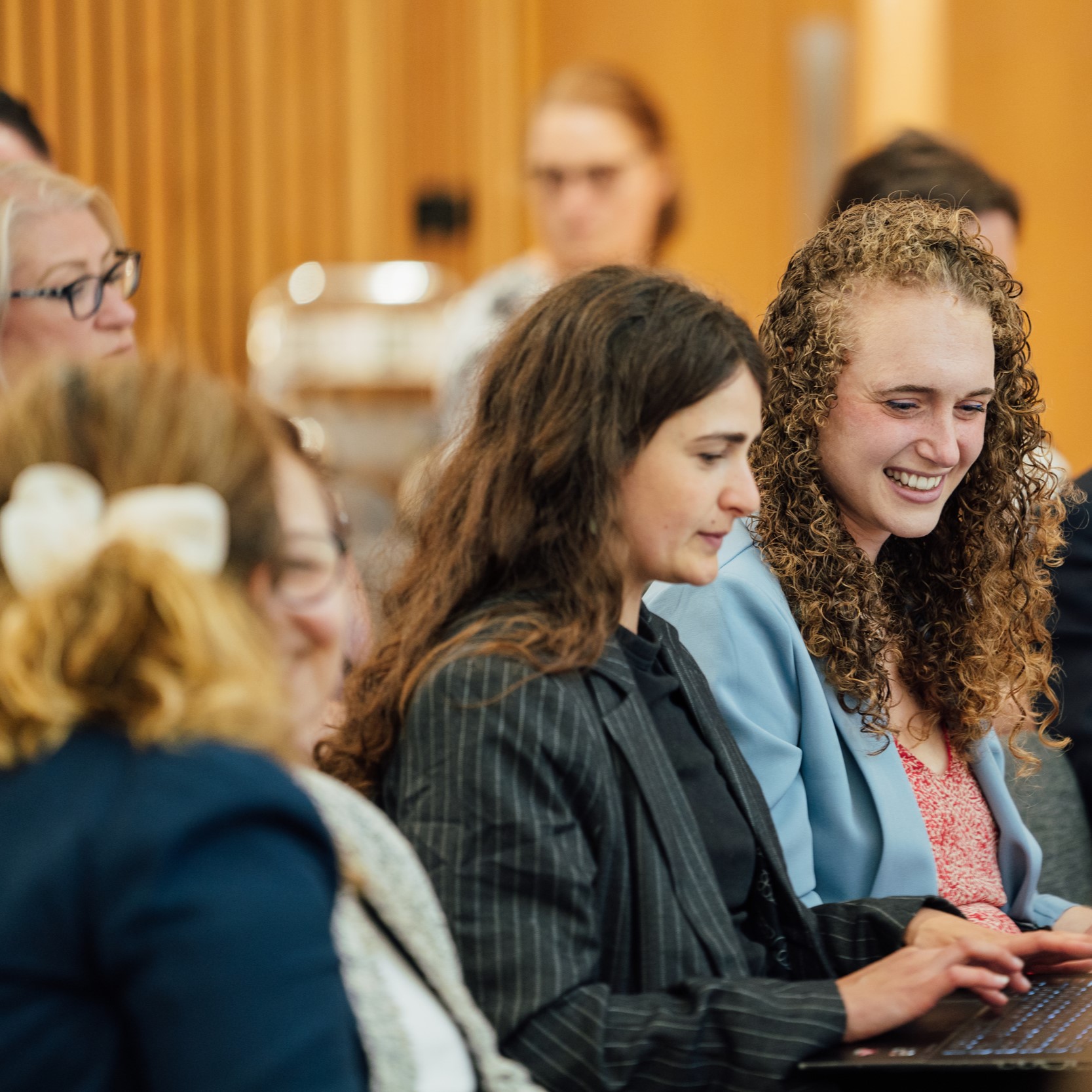Image for decoration only, focussing on two young scholars sat in a crowd